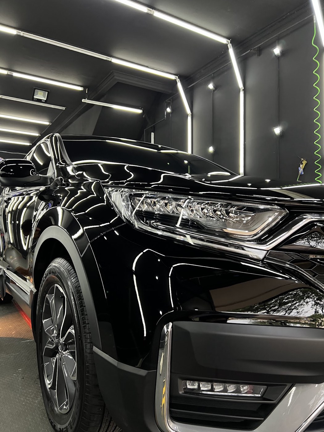 Freshly detailed black SUV under the studio lights at OTOWORX