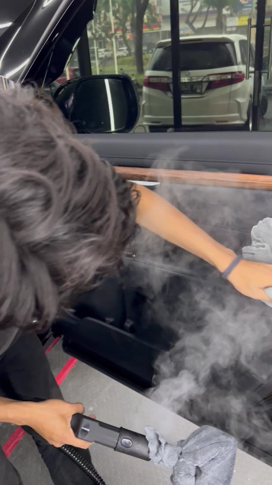 Steam cleaning a car door panel at OTOWORX